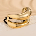 Close-up of sleek curved gold metal hair cuff with black elastic on textured stone - Gold 1090574