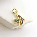Detailed macro shot of a golden bird pendant with colorful zircon stones on white stone - Flying Bird