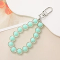 Detail of mint green transparent beads on a phone strap with a silver lobster clasp - Green