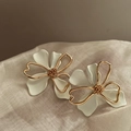 Close-up of double-layer hollow flower stud earrings with white enamel and gold lines - White