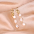 Minimalist gold knotted earrings with three baroque pearls hanging on satin fabric - Asymmetric 3-Pearl Curved Pin Style