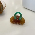 Close-up of a brown acetate hair claw clip with a green horseshoe design and gold numbers - Green Coffee Handbag Small