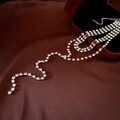 Detail of a luxury layered diamond tassel necklace on elegant red silk and velvet - Silver Rhinestone Tassel Necklace
