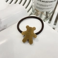 Close-up of a brown resin bear pendant engraved with Amy Bear on a brown hair tie - Bear Cookie Hair Tie / Milk Brown