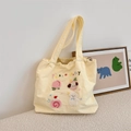 Detail der süßen Peach Puppy Stickerei und Patches auf einer gelben Canvas-Einkaufstasche - Rosa Pfirsich