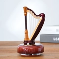 Vintage wooden harp music box with golden accents and strings on a warm tabletop - Harp Music Box