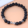 Detail of black lava stone bracelet featuring a silver metal dumbbell bead accent - Dumbbell