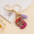 Detail of red glitter resin number 9 keychain with purple tassel and star sequins glass ball - Number 9