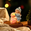 Dettaglio di una palla di neve rosa luminosa e una statuetta natalizia in ceramica - Stile Ragazza Dipinta