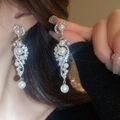 Gros plan sur des boucles d'oreilles en S avec cristaux et perles portées par un mannequin - 58# Pampille en Perle Forme S Argent (HE3995)