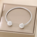 Macro shot of silver twisted cable bangle featuring two crystal-pave spheres at ends - Steel Color (KB187870-XY)