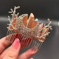 Detailed view of silver crescent moon and branch hair comb with orange crystal columns - Brown + Branch + Moon