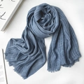 Lightweight blue cotton linen scarf with pleated texture and fringe tassels on wood surface - 1477 Modal Navy Blue