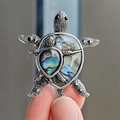 Detail of a turtle brooch featuring iridescent abalone shell and silver metallic texture - Double Turtle Style