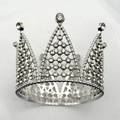Macro detail of silver alloy crown cake topper with sparkling crystals and lattice design - White K/Silver