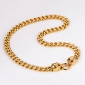Detail of gold Cuban chain necklace with dual skull heads clasp on white background - 13mm / Gold