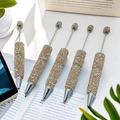 Sparkling champagne gold beaded pens with full rhinestone finish on white book background - Champagne