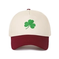 Detailed close-up of green shamrock embroidery on a two-tone cotton baseball cap - Beige Crown + Wine Red Brim