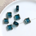 Detailed view of blue square glass beads with gold edges for DIY jewelry making - Teal