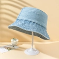 Cappello bucket in denim azzurro con ricamo a squalo su un supporto bianco minimalista - M (56-58cm) / Azzurro