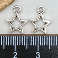 Pair of hollow star-shaped silver pendants with a ruler showing the 1.2cm width - Antique Silver Small Star (10x12mm)