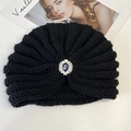 Detailed texture of black knit turban hat with vintage silver and purple jewel ornament - Black