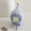 Close-up of color-block knit baby hat with pointed top, pompom, and chin straps - 6-24 Months / Blue