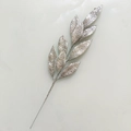 Macro shot of silver glitter coated artificial branch with detailed leaf textures for decor - Silver