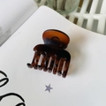 Deep brown amber tortoiseshell hair claw clip for medium ponytails on a notebook - Matte Reddish Brown (Medium 4.8cm)