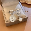 Detailed shot of asymmetric silver coin earring and white pearl drop on leather padding - 32# Silver Pin - Silver Chain Pearl Portrait