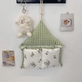 Dettaglio dell'organizer da parete in tessuto a quadretti verdi, tasche floreali e pizzo decorativo - Quadri Verdi