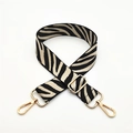 Close-up of zebra pattern woven bag strap with adjustable gold-tone metal buckles - Light Khaki