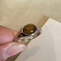 Vintage S925 silver ring with brown oval resin stone shown in a close-up hand-held view - Silver Oval Tiger Eye Stone