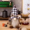 Gnomo da caffè con cappello a quadri bianco e nero e chicchi di caffè sul tavolo - Gnomo in Piedi con Cappello a Quadri e Sacco di Caffè
