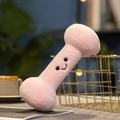 Peluche a forma di manubrio rosa con faccina sorridente accanto a cesto d'oro - Manubrio Rosa / 20cm