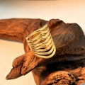 Goldfarbener mehrlagiger Wellenring mit Granulatstruktur auf rustikalem Holzhintergrund - Mehrlagige Welle Granulat Gold / Gold