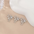 Close-up of three silver bow-heart pendants with white zircon insets on pink leather - Heart Stone Ribbon Bow (PJ0313) / Silver