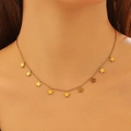 Close-up of a gold star charm choker necklace on a model showing fine chain links - Gold Star
