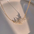 Elegant gold necklace with sparkling zircon flower pendant on a beige ceramic plate - Peony Flower Pendant