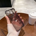 Detail of dark grey transparent case with reinforced corners on a hand-held iPhone - iPhone 15 / Transparent Black