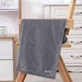 Dark grey cotton towel with wave texture and SLOW LIFE label on a wooden chair - Wavy Tiger Pattern - Grey Blue