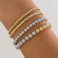 Macro shot of layered gold and silver beaded metal bracelets featuring heart pendants - Mixed Colors 4713