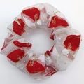 Close-up of white mesh scrunchie with festive red patterns and sparkling gold glitter - Christmas Hat