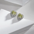 Macro detail of heart-shaped yellow zircon earrings on minimalist white stone display - Heart Shape Olive Yellow Zirconia Studs