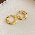 Detailed close-up of gold plated chunky hoop earring with white zircon on leather - Gold