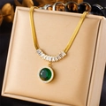 Detailed view of emerald green stone necklace with gold chain on black silk background - Green Gemstone Zirconia Style (N2689)