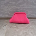 Detailed close-up of bright pink knitted cloud clutch bag with textured fabric - Pink