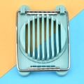 Gros plan d'un coupe-œuf bleu avec fils en acier inoxydable sur fond bicolore moderne - Vert Gris