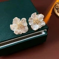 Dettaglio macro di orecchini a fiore con perle e zirconi su scatola di pelle verde - Placcato Oro Vero Perno in Argento Stile Fiore di Perla / Oro Bianco