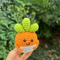 Close-up of hand-knitted carrot doll with a positive message card in high detail - Plump Carrot